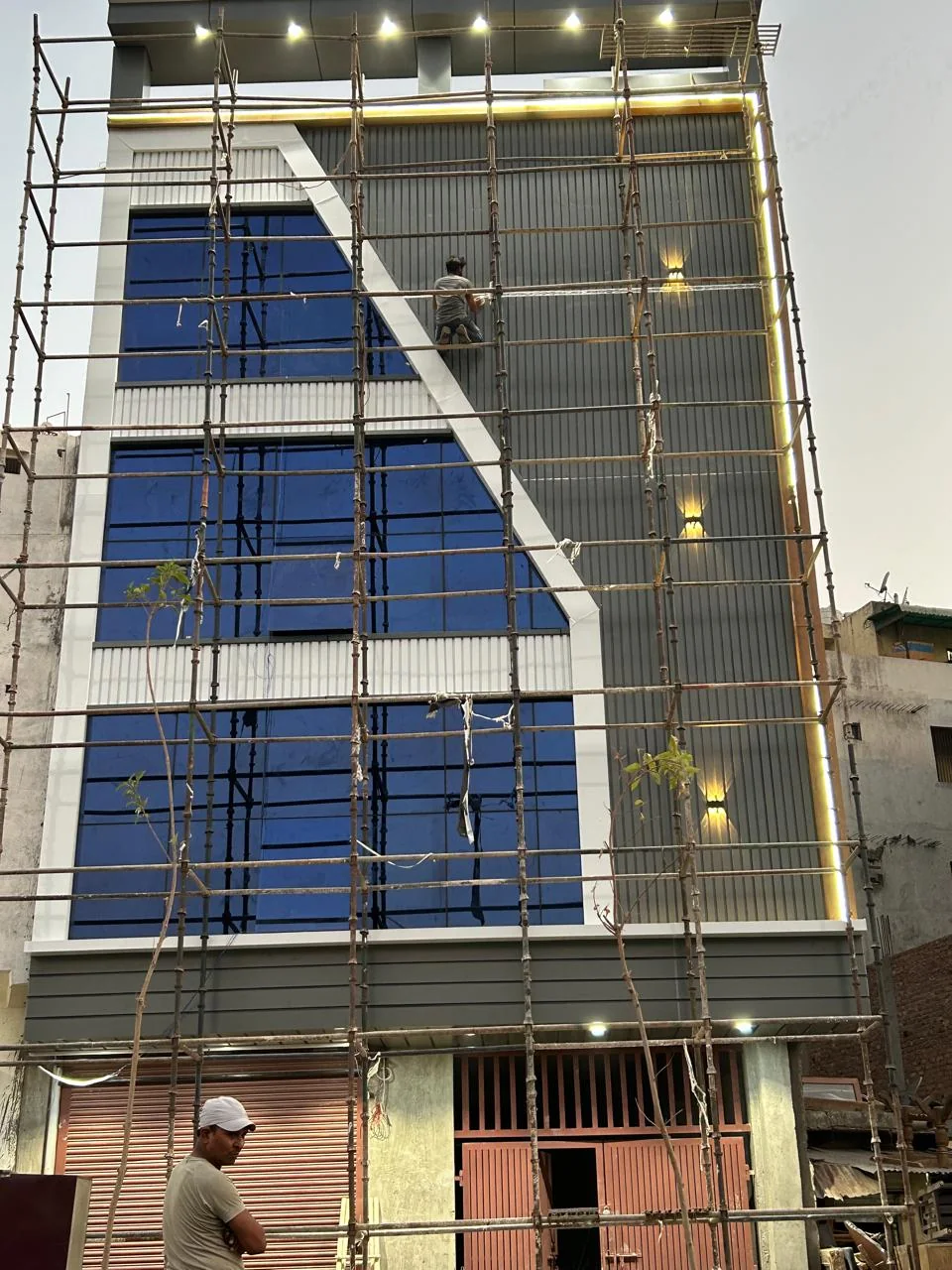 Façade installation in progress with scaffold.