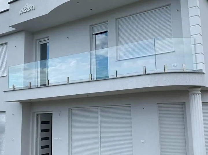 White residential exterior with glass balcony railings.